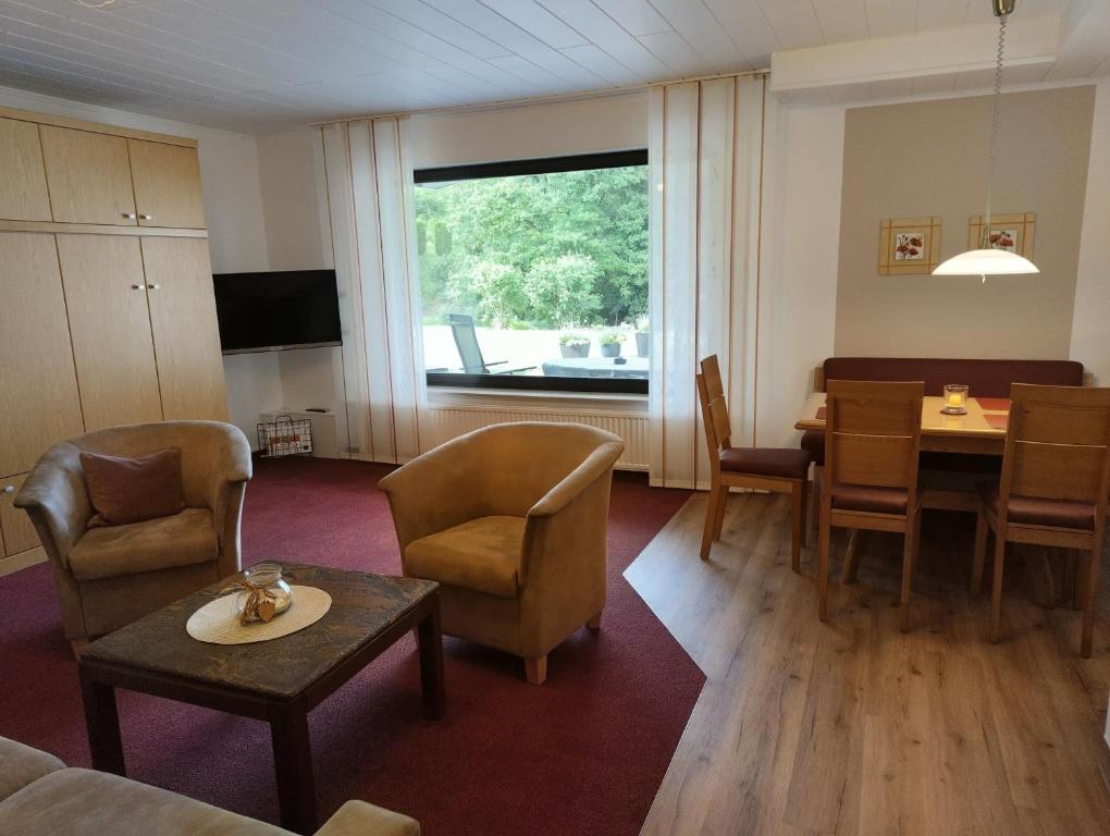 a dining room with a table and chairs and a window at Ferienhaus am Sonnenhang in Willingen