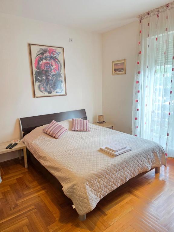 a bedroom with a bed with two pillows on it at Laki Apartment in Podgorica