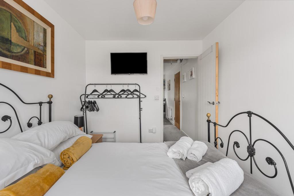 a bedroom with two beds and a tv on the wall at Badger Haven, Apartment 3 in Brackley