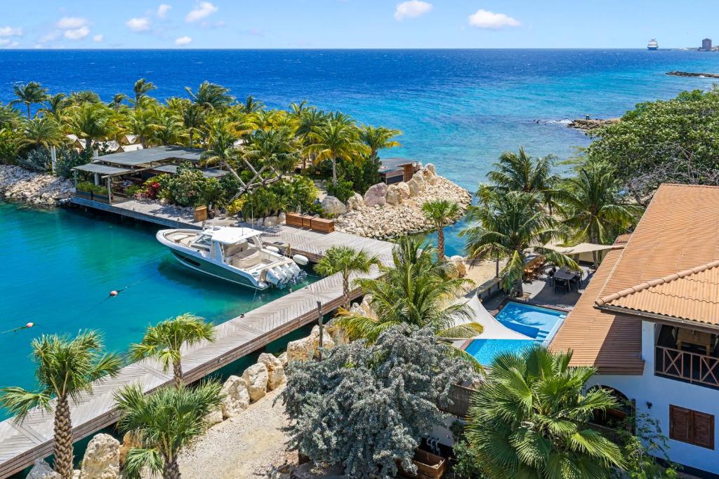 an aerial view of the resort with a boat in the water at Atlantis Beach House in Willemstad