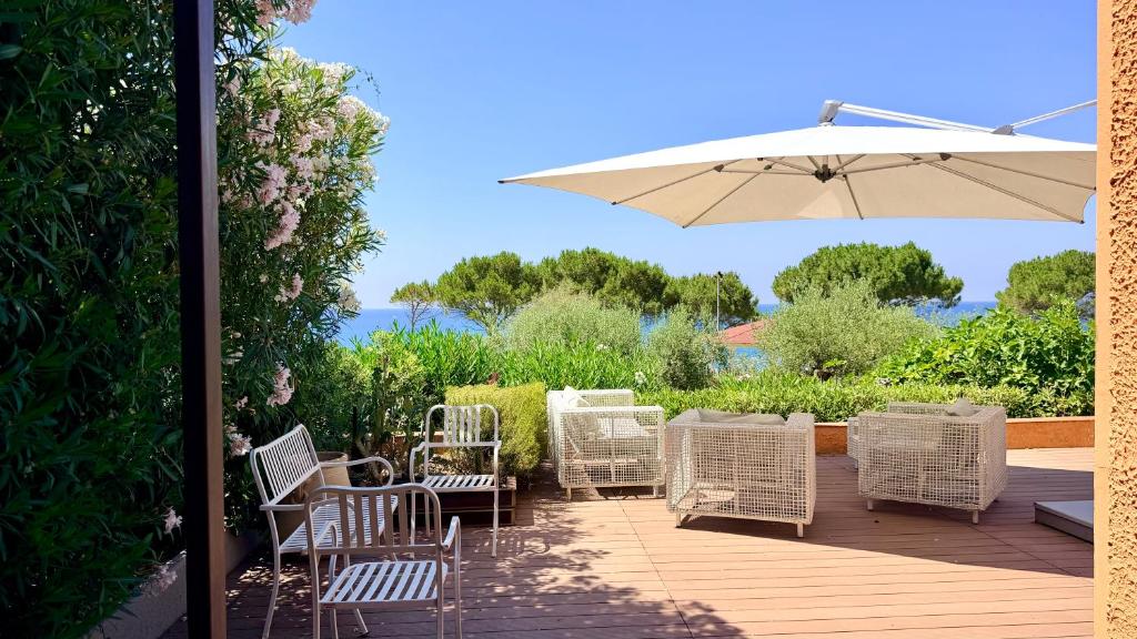 a group of chairs and an umbrella on a deck at Villa Edo Cefalù in Cefalù