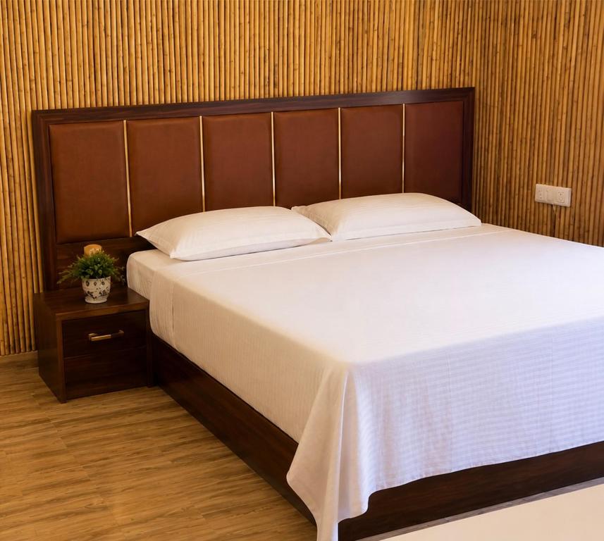 a large bed with a wooden headboard in a room at Poolside Paradise in Ghaziabad