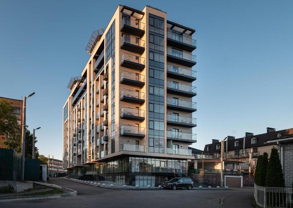 a tall building with a car parked in front of it at Azamra in Uman