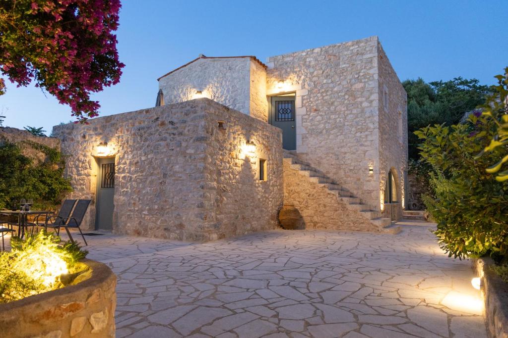 a stone building with a stone patio and stairs at Mainotti's house with balcony in Areopoli