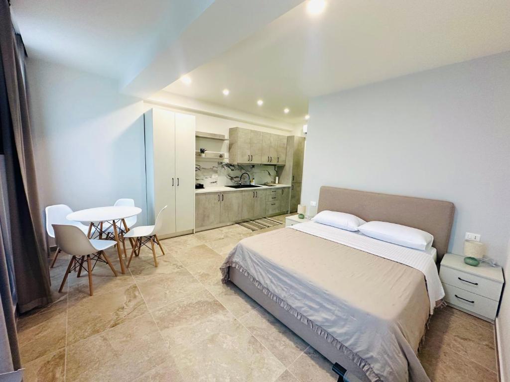 a bedroom with a bed and a table and chairs at Tanushi Central Apartments in Vau i Dejës