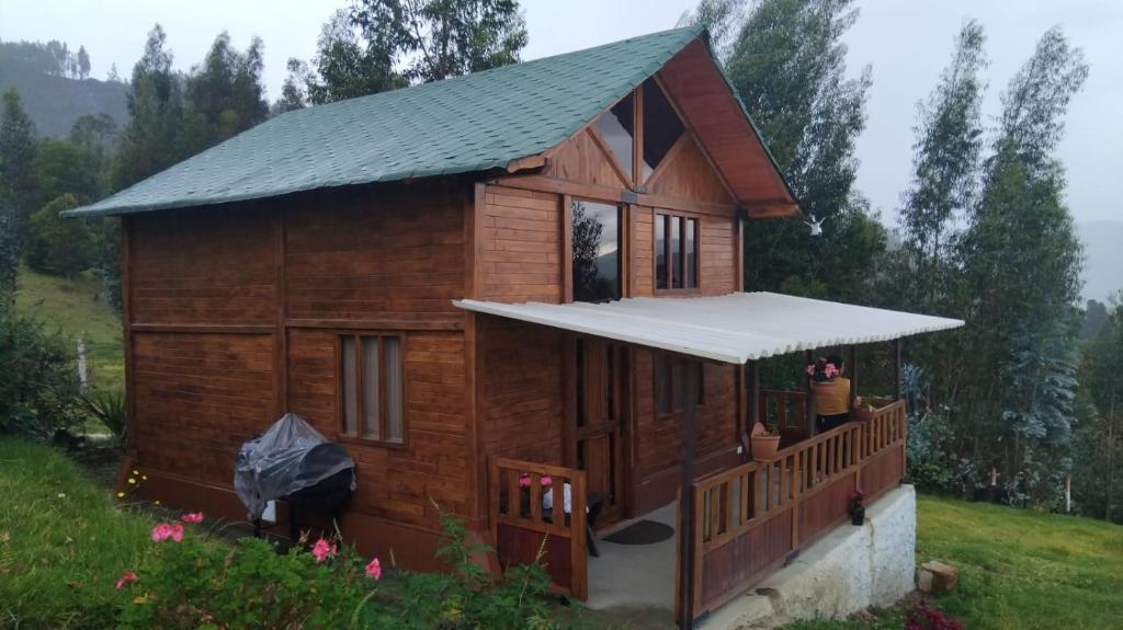 a small wooden cabin with a porch and a roof at Cabaña Buenos aires in Sogamoso