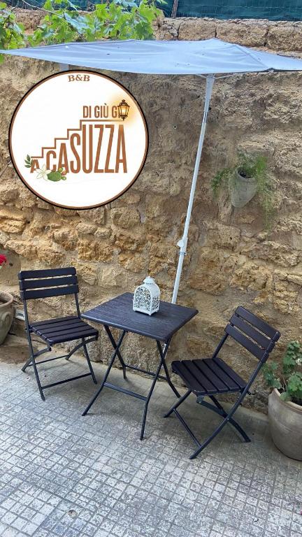 a table and two chairs sitting under a sign at A Casuzza di Giú Giú - NUOVA GESTIONE in Agrigento