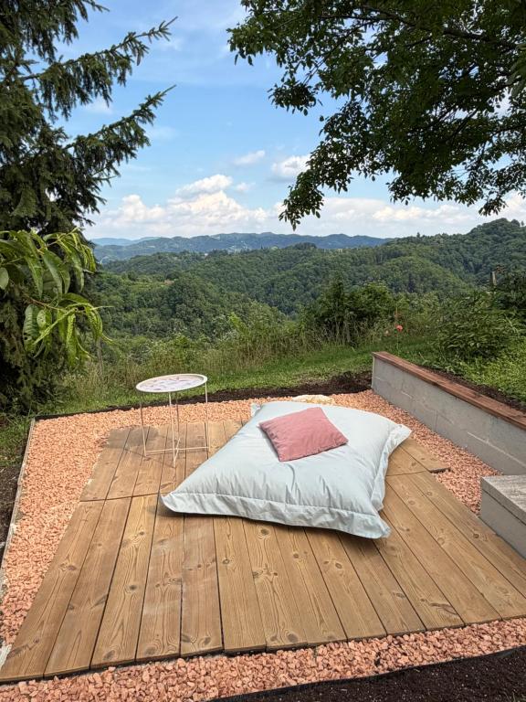 a bed on a wooden deck with a table at Haloze Chill in Podlehnik