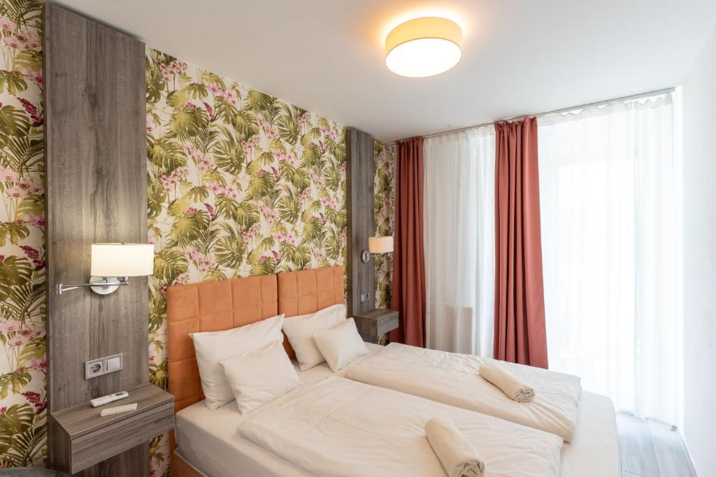 a bedroom with a bed and a floral wallpaper at Lakeside Apartment Sunset Resort in Fonyód