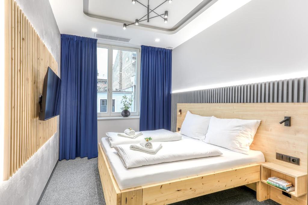 a bedroom with a bed with blue curtains at Apartmány Prusinovského in Kroměříž