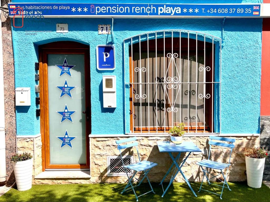 a blue building with stars on it with a table and chairs at Pensión RENCH in Alcossebre