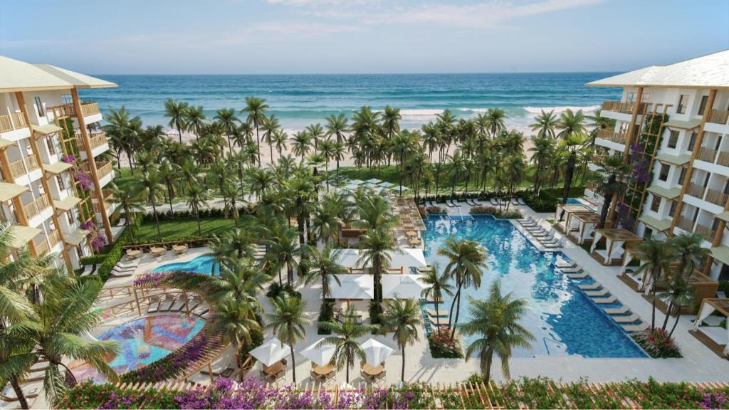 an aerial view of a resort with a pool and the ocean at Beach Park Resort - Ohana in Aquiraz
