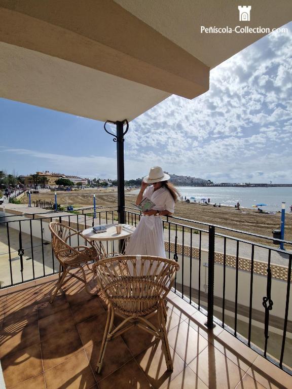 a woman standing on a balcony looking at the beach at Villa Brisamar - On the beach in Peniscola