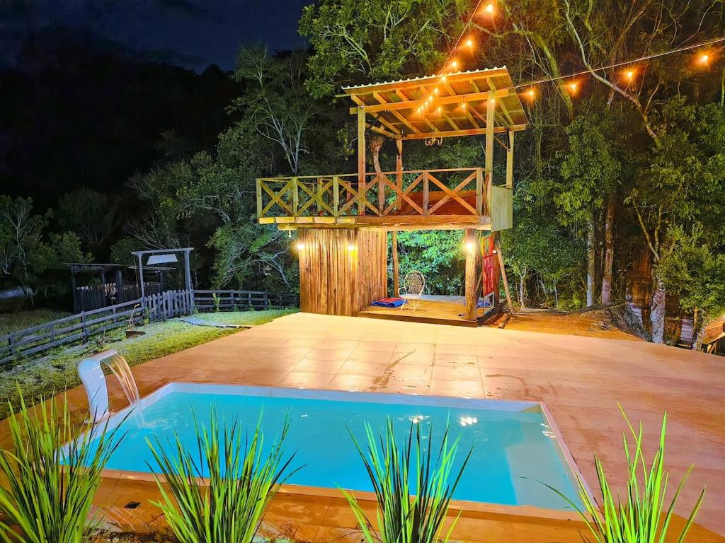 a house with a swimming pool and a pergola at Villa Pitanga Pousada in São Martinho