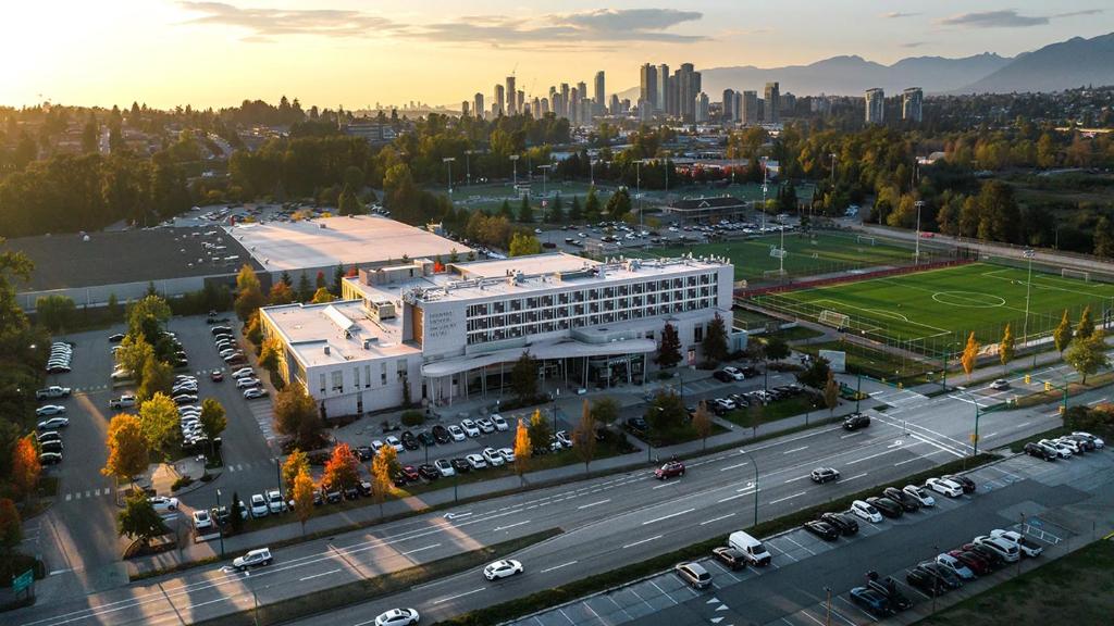an aerial view of a large building with a parking lot at Hotel Burnaby in Burnaby