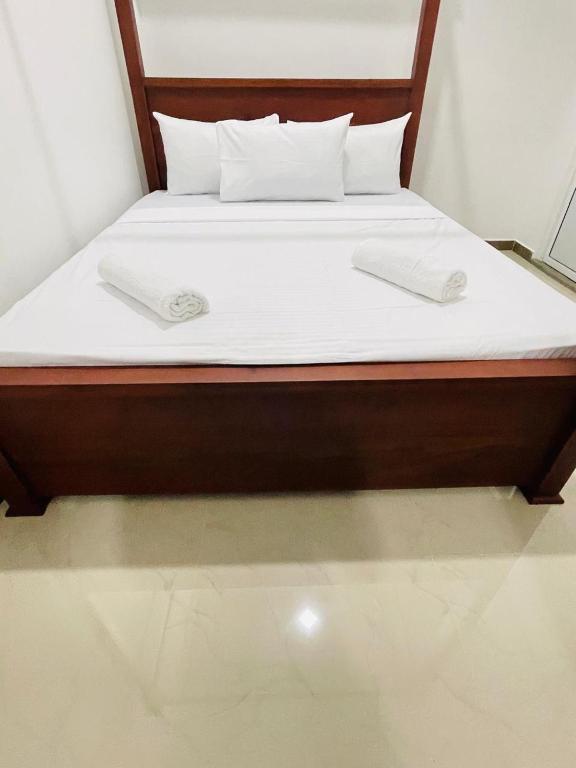 a bed with white sheets and pillows on it at Kalupahana Villa in Beruwala