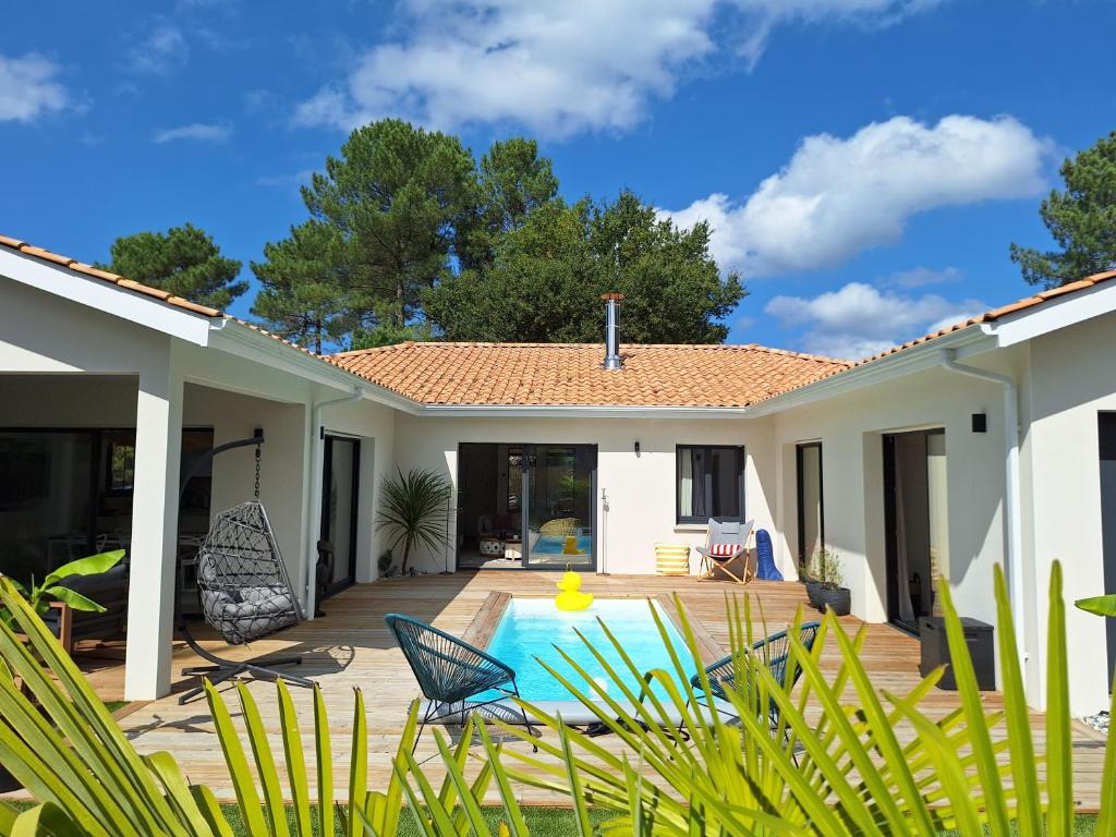 a house with a patio and a swimming pool at Villa Céline - Prestige, Piscine & Jacuzzi in Vielle-Saint-Girons