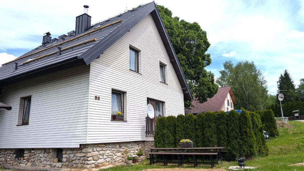 a white house with a bench in front of it at Apartmány u Bernardů in Stožec