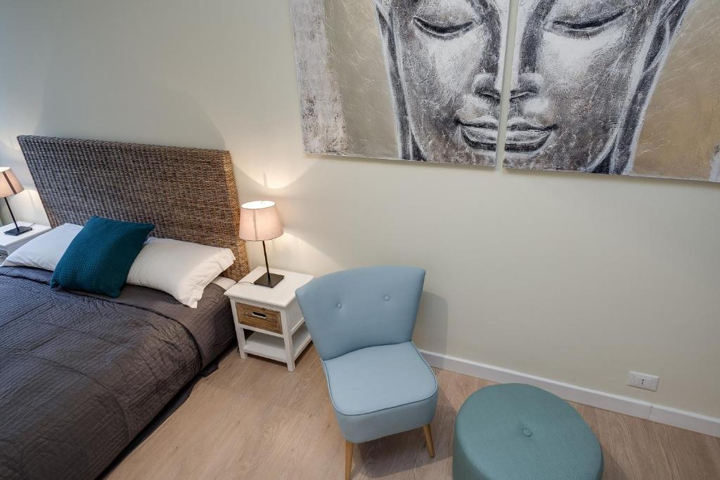 a bedroom with a bed and a chair and a painting at Romefinestay Apartments Sistina in Rome
