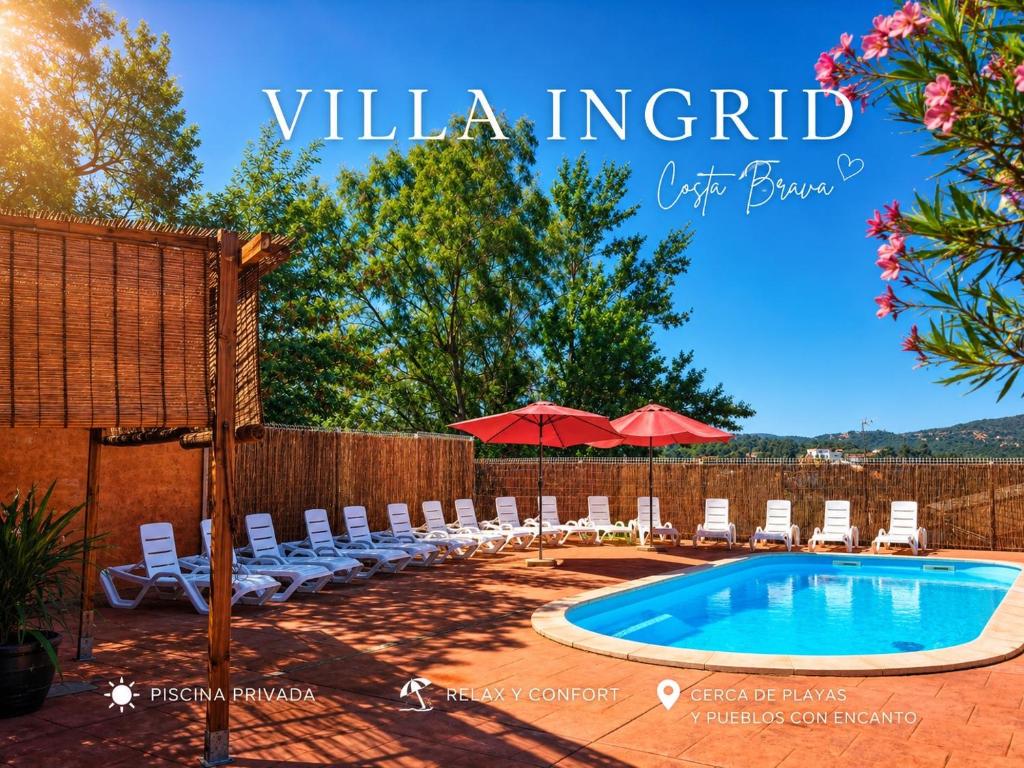 a pool with chairs and umbrellas next to a fence at Villa Ingrid Costa Brava in Vidreres