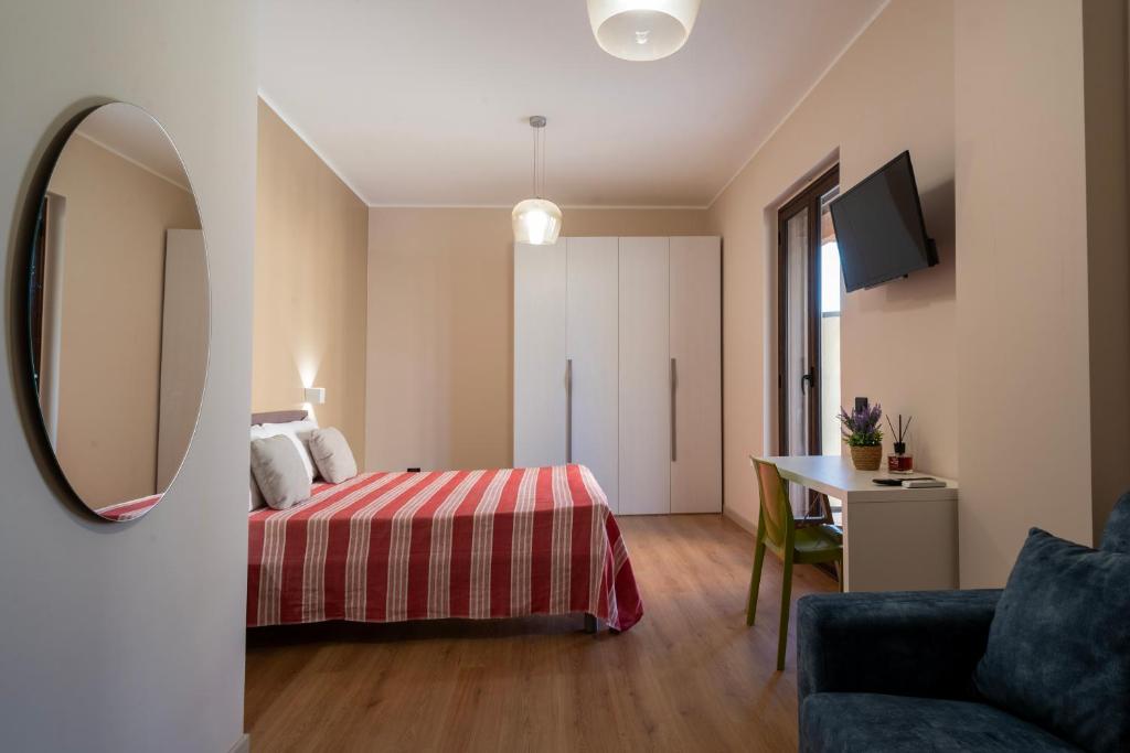 a bedroom with a bed and a table and a mirror at ISA ROOMS Bed&Breakfast in Bovalino Marina