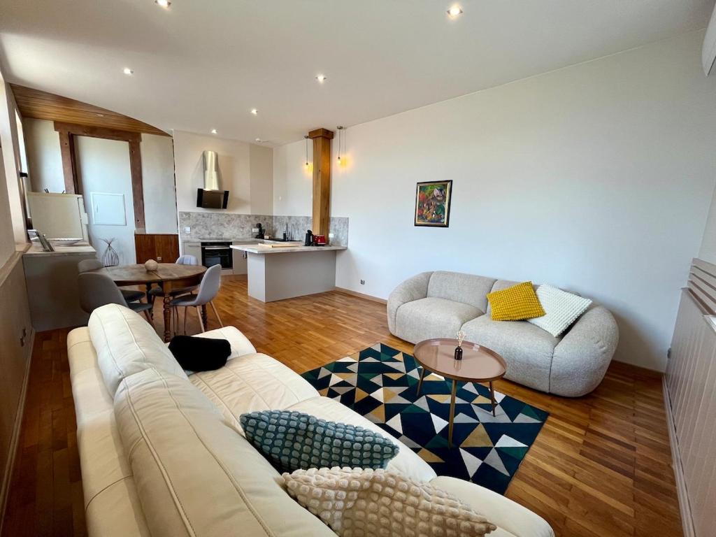 a living room with a white couch and a table at Appartement 93m2 Cosy - 2 chambres in Wimmenau