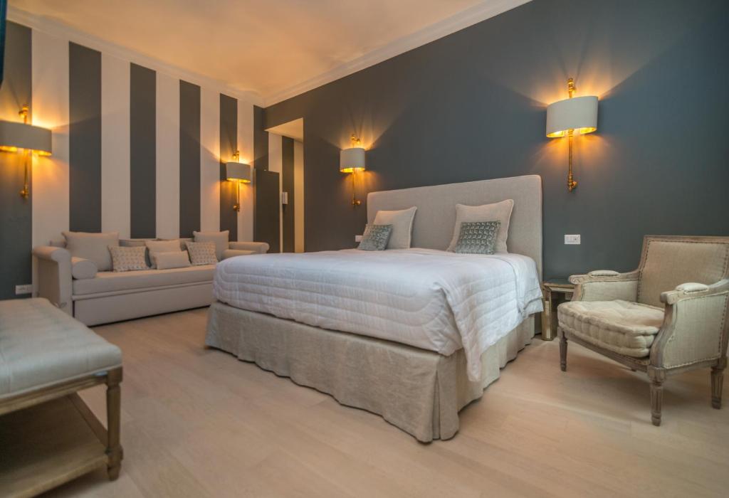 Brera Luxury Suite في ميلانو: غرفة نوم بسرير واريكة وكرسي