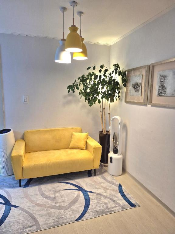a yellow couch in a living room with a rug at 원하우스 in Seoul