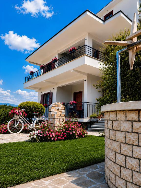 a white house with a balcony and a bike at Villa Tabaku in Berat