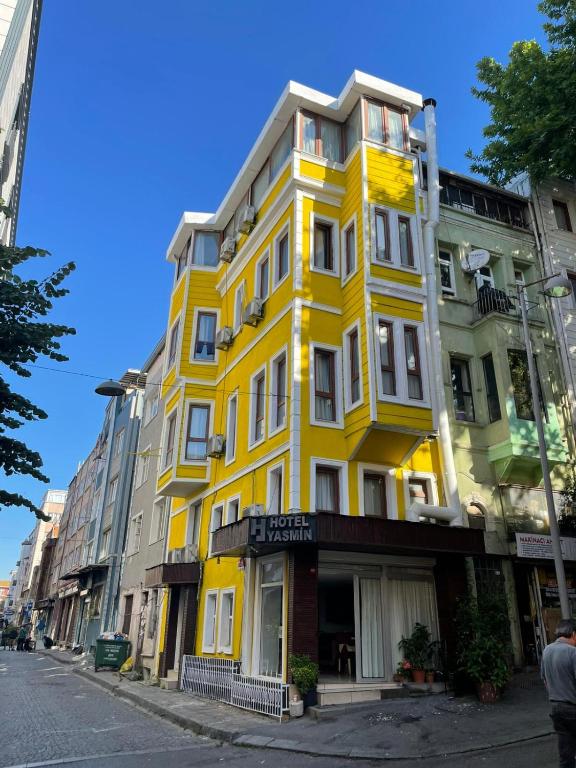 ein gelbes Gebäude am Straßenrand in der Unterkunft YASMİN Hotel in Istanbul