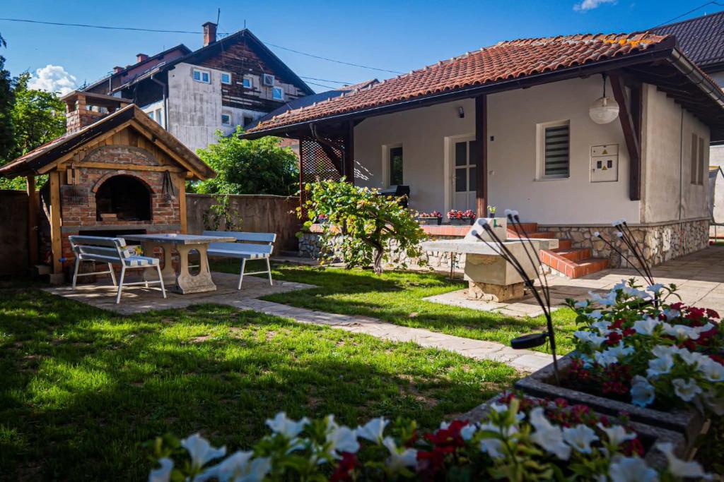 a backyard with a table and a house at AG Apartmans in Gornji Vakuf