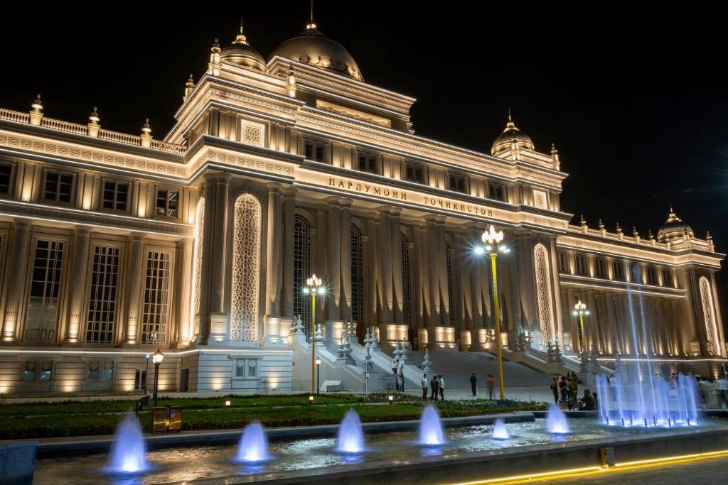 a large building with a fountain in front of it at Paziro Hotel in Dushanbe