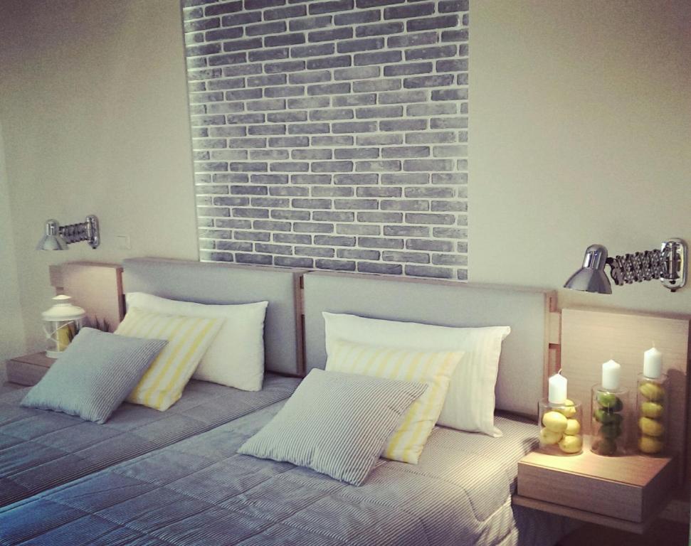 a couch with three pillows and a brick wall at Galaxy City Hotel in Limenas