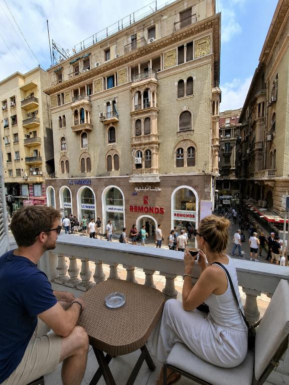a man and a woman sitting at a table on a balcony at Velvet city view in Cairo