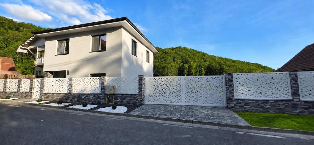 a white house with a fence in front of it at Cataleya House Sovata in Sovata