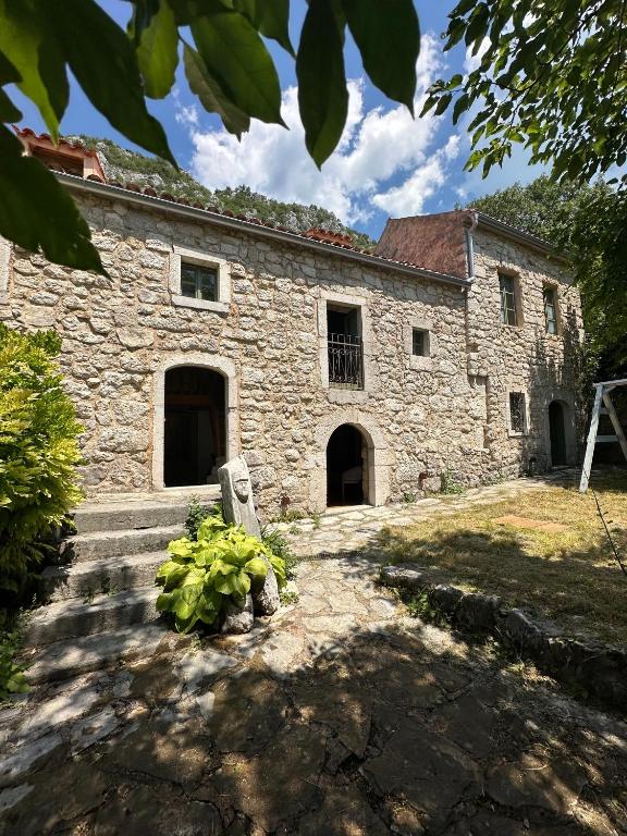 an old stone building with a bunch of plants in front at Authentic Stone House Tranquil Villa for Families and Groups in Grižane