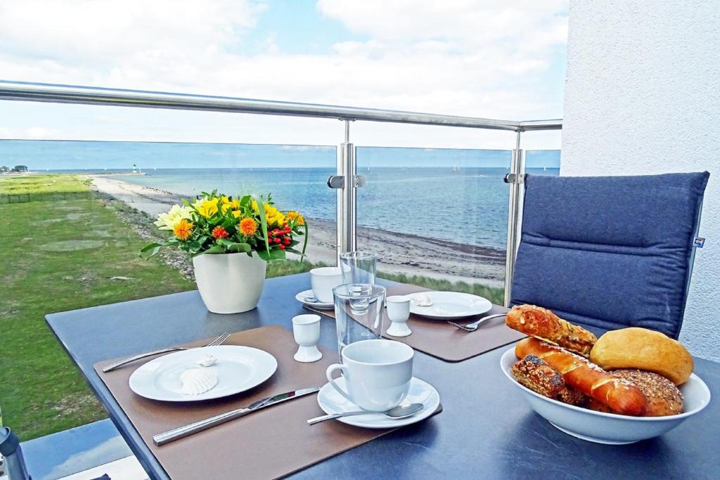 a table with a bowl of pastries and a view of the ocean at Sturmvogel in Olpenitz