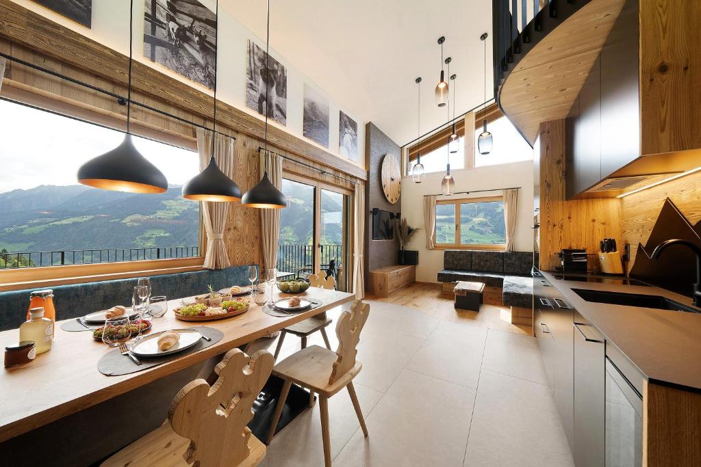a kitchen and dining room with a table and chairs at Chalet Bucher in Rifiano