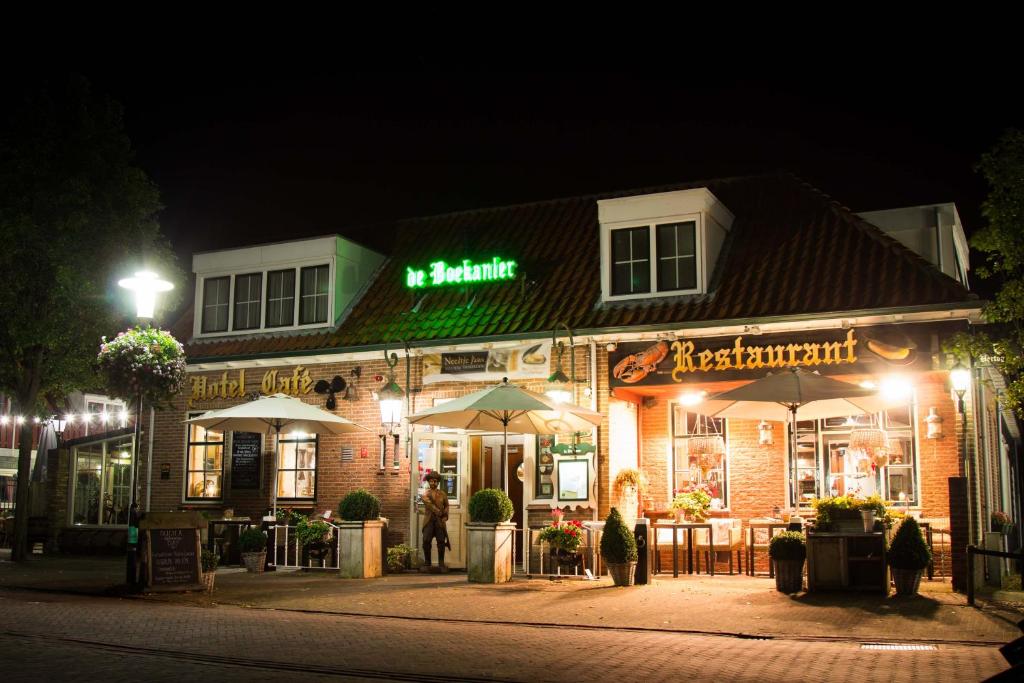 a building with umbrellas on a street at night at Hotel Restaurant de Boekanier in Vrouwenpolder