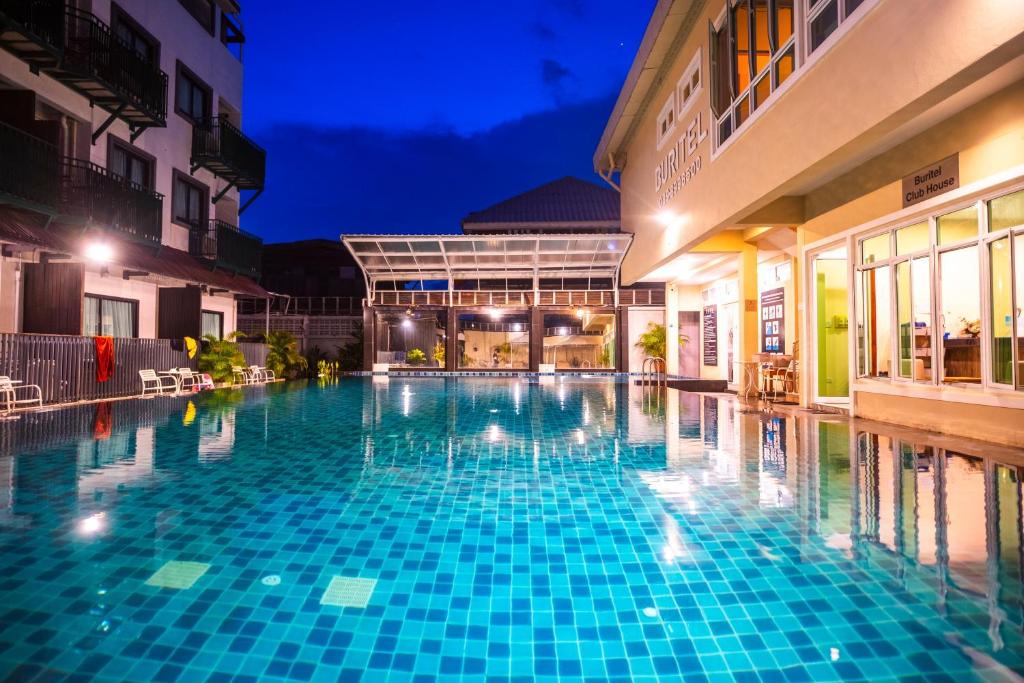 a swimming pool in a hotel at night at Buritel Hotel in Buriram