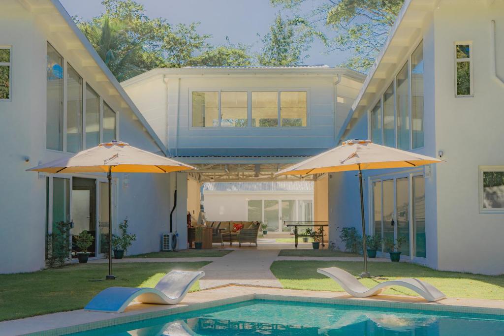 ein Haus mit Swimmingpool und zwei Sonnenschirmen in der Unterkunft T Loft in Playa Hermosa