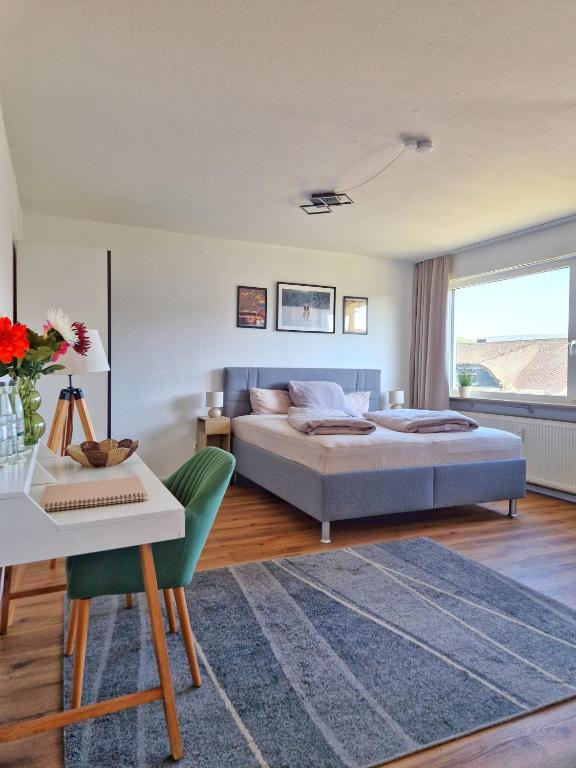 a bedroom with a bed and a table and a desk at FeWo Talblick - modern, charmant, Feldrand in Bad Orb