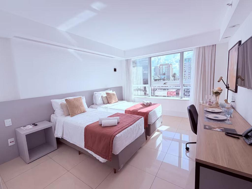 a hotel room with a bed and a desk and a desk at SOFISTICADO Flat Brasília no Eixo Monumental, Melhor Localização de Brasília in Brasília