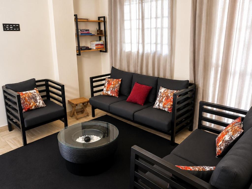 a living room with a couch and two chairs at Home23 Apartments in Jinja