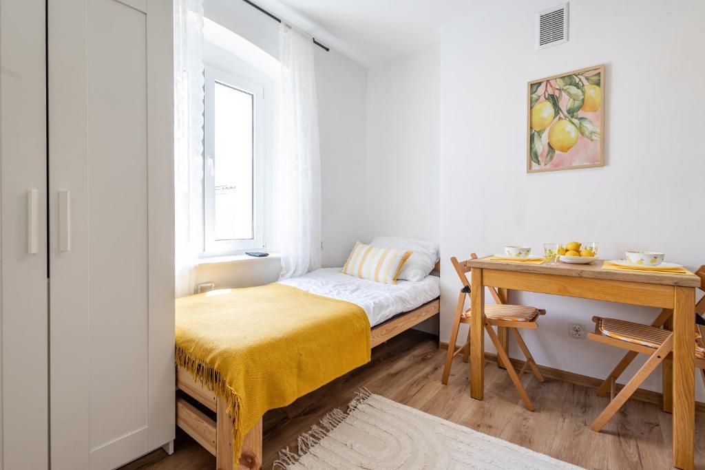 a small bedroom with a bed and a desk at Apartament Cytrynowy Kwidzyn in Kwidzyn