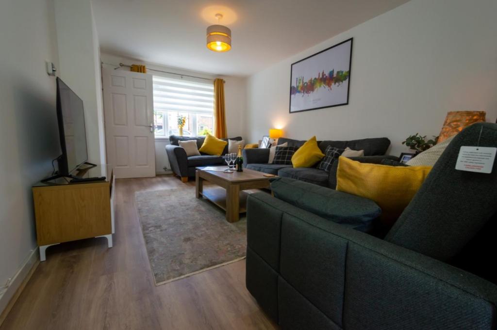 a living room with a couch and a tv at Spacious 5BR Home St Andrews in Fife