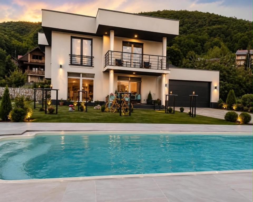 a house with a swimming pool in front of a house at LUX Villa Mavrovo in Mavrovo