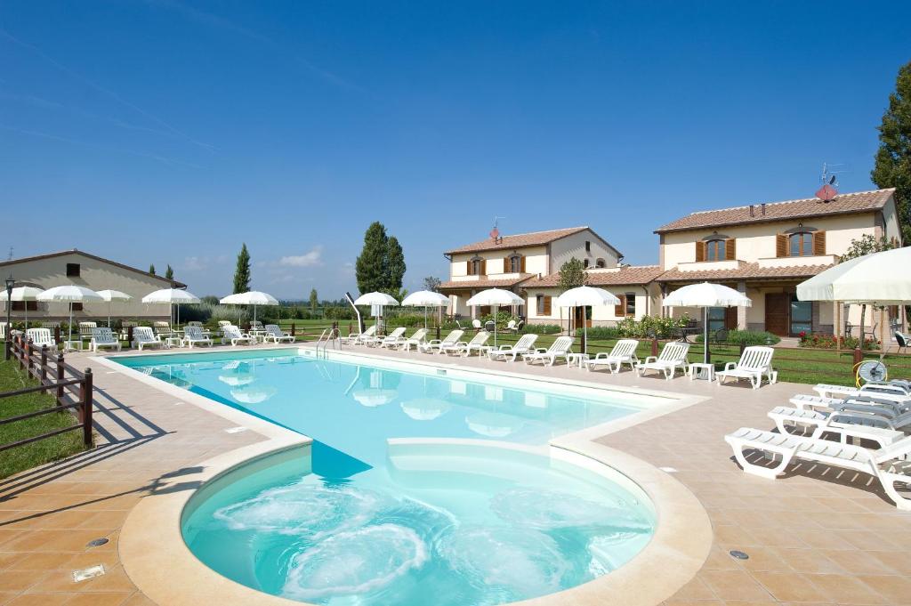 a pool with chairs and umbrellas in a resort at Agriturismo Le Rondini Di Francesco Di Assisi in Cannara