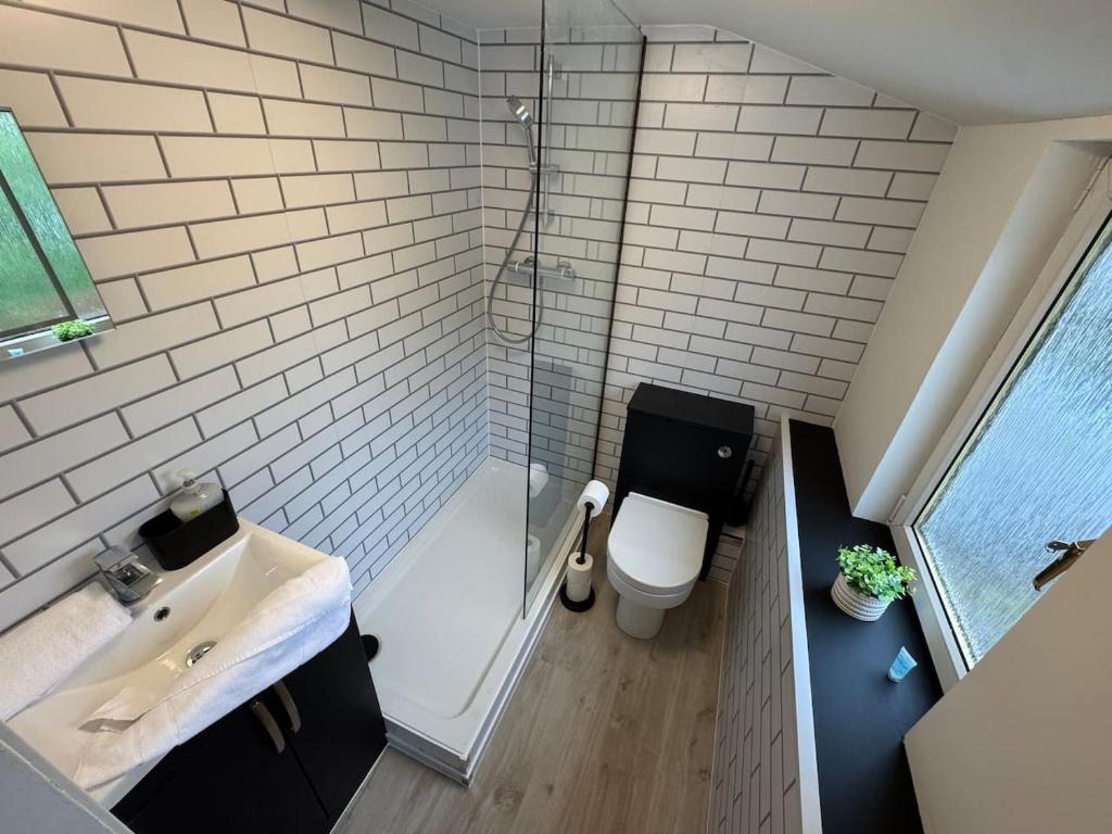 a bathroom with a shower and a toilet and a sink at Modern 3BR home in Cumbernauld in Cumbernauld