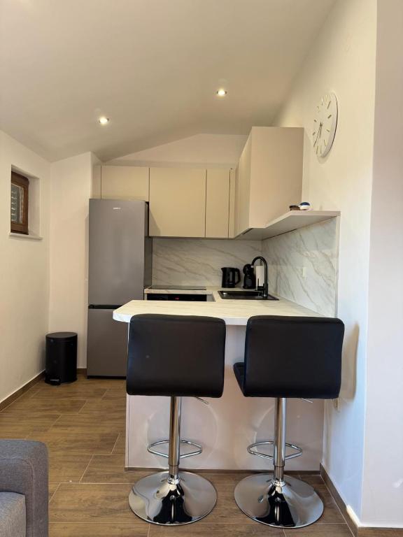 a kitchen with a counter and two bar stools at Apartment Sidro in Posedarje
